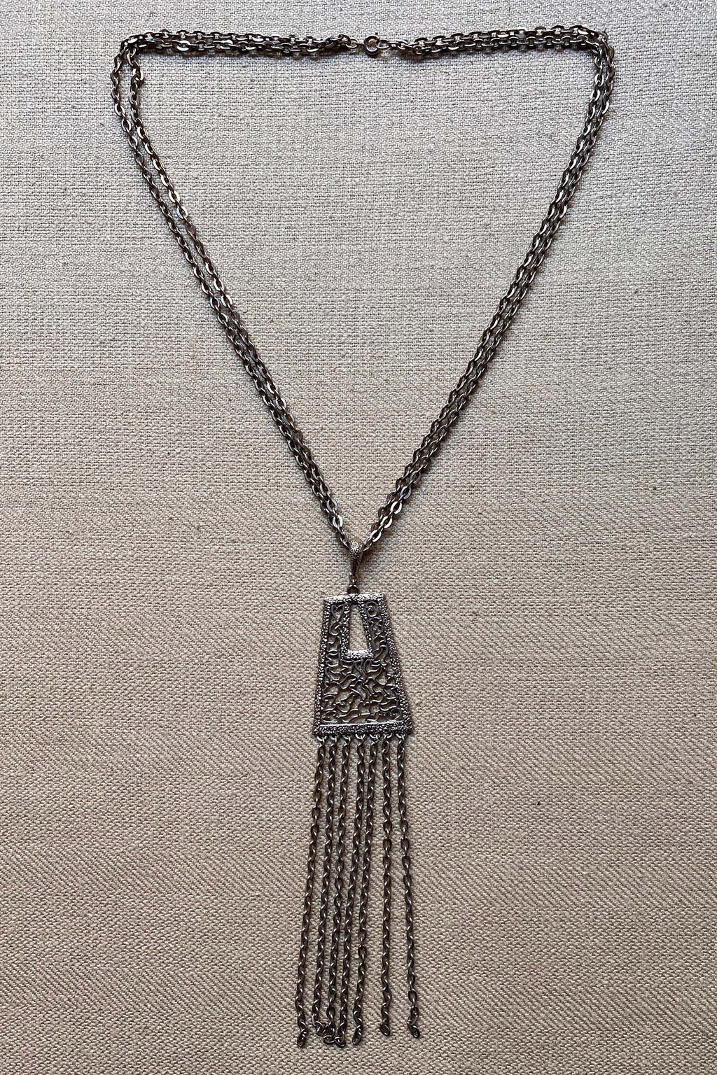 Silver tone tassel and filigree pendant necklace