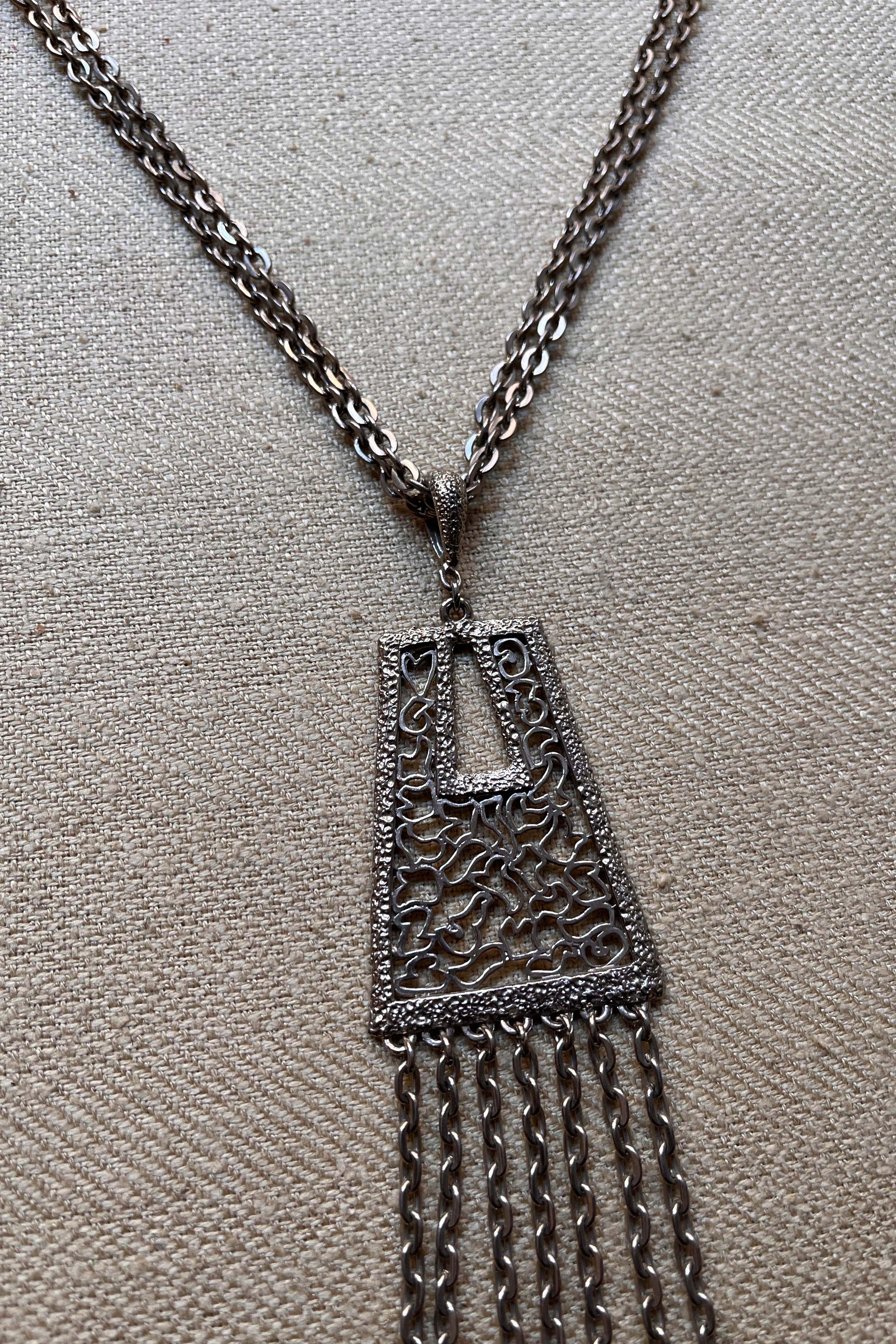 Silver tone tassel and filigree pendant necklace
